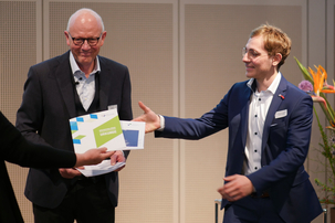 Auszeichnung des Preisträgers Daniel Dlubal auf der Bühne mit einer Teilnahmeurkunde.