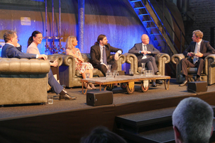 Die Podiumsdiskussion auf der Bühne, moderiert durch FAZ Wirtschaftsredakteur Dyrk Scherff